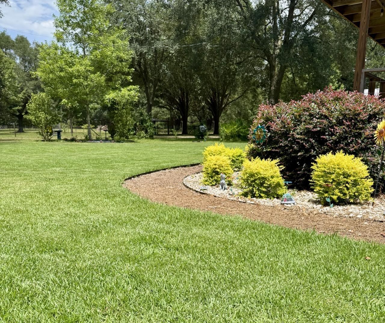Healthy green lawn and vibrant ornamental shrubs maintained by Stewart Pest Control